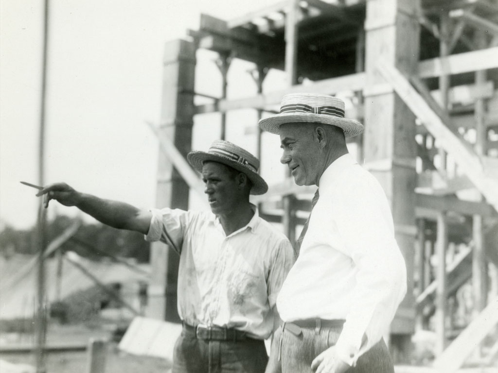 Yost, with a contractor, surveys the construction of his crowning achievement, Michigan Stadium.